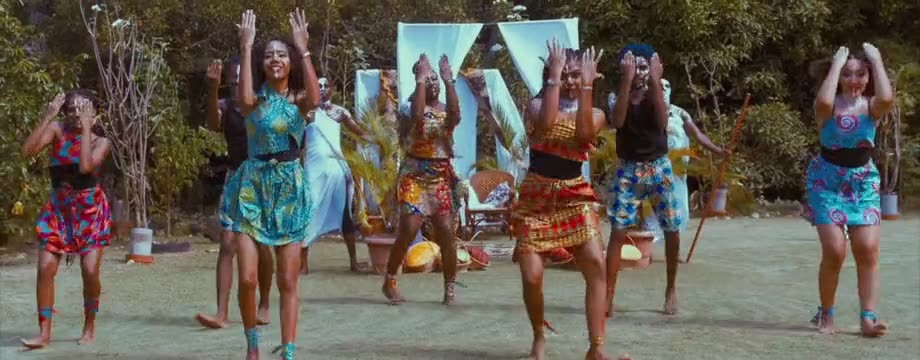 A dance group performing outdoors in bright costumes