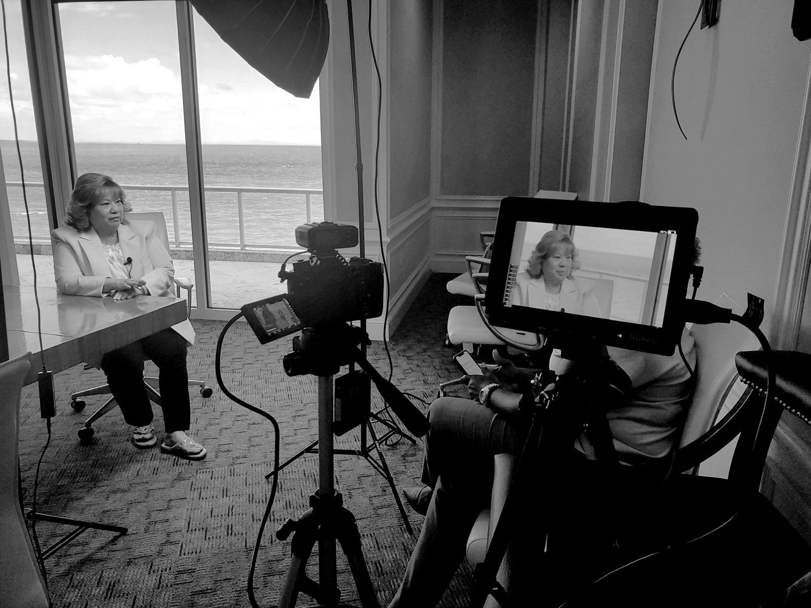 A boardroom interview overlooking the sea, framed on the field monitor
