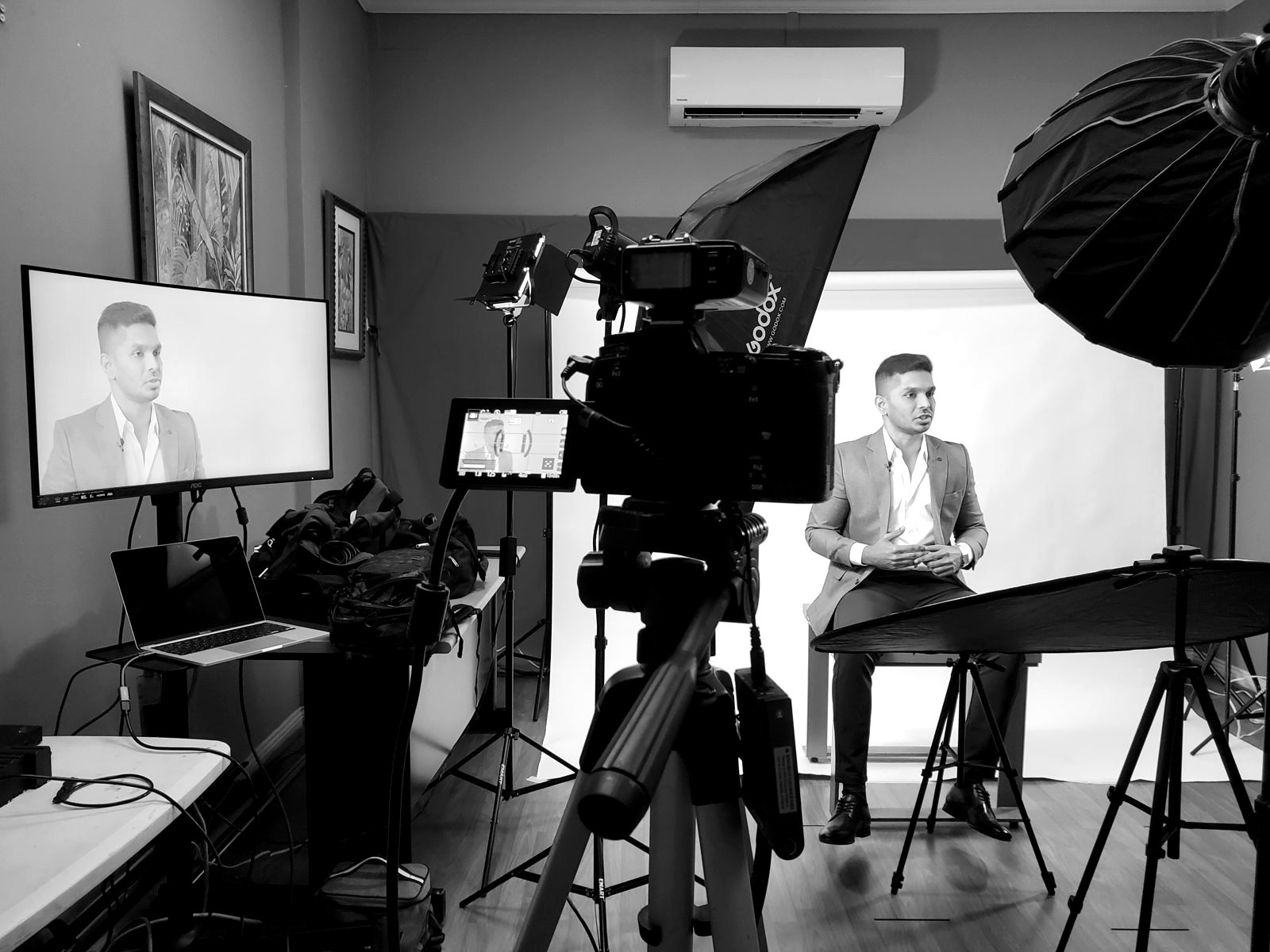 A studio interview on white seamless, the camera and monitor in the foreground