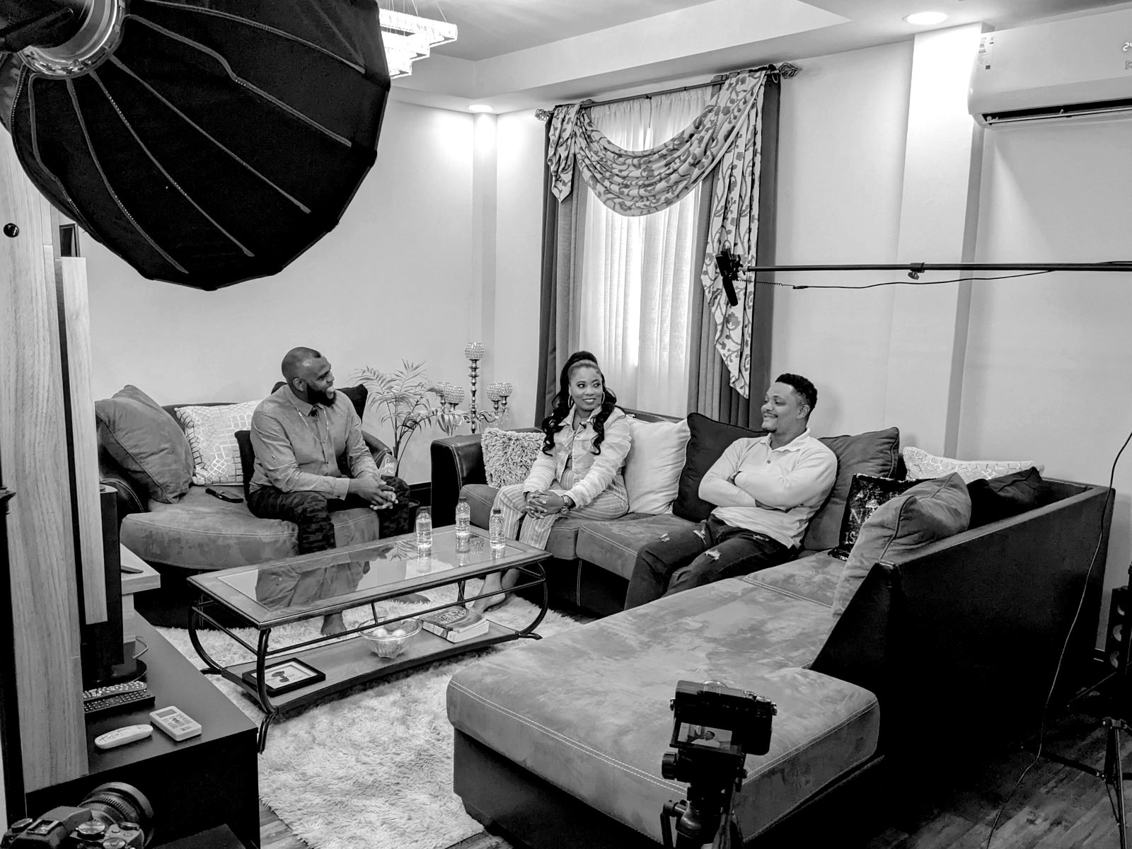 A three-person podcast filmed in a living room with a boom microphone